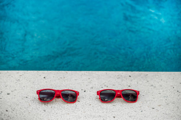 two red sunglasses at swimming pool. copy space - ravena imagens e fotografias de stock