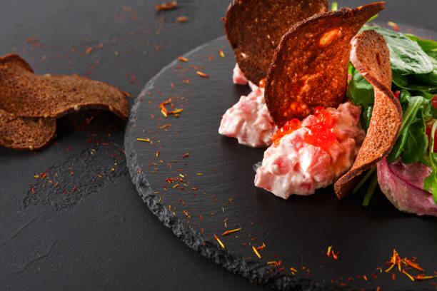 グルメ シーフード スナック黒プレ�ートにクローズ アップ - plank bread caviar close up ストックフォトと画像
