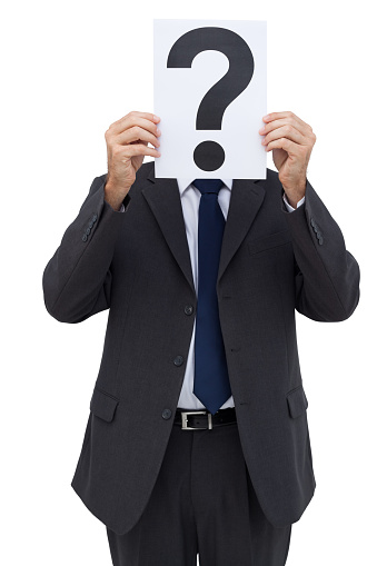 Businessman holding a question mark paper in front of his face on white background