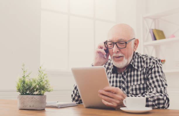 istock Senior man talking on phone with tablet 849249406