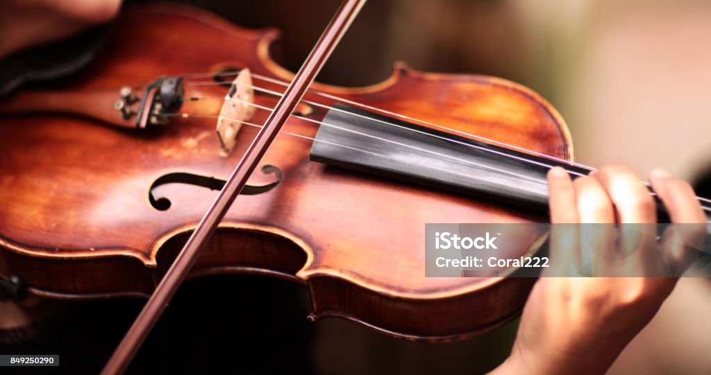 A person playing the violin showing hands holding the bow Bow - Musical Equipment, Arts Culture and Entertainment, Violin, Musical Instrument, Outdoor Violin Stock Photo