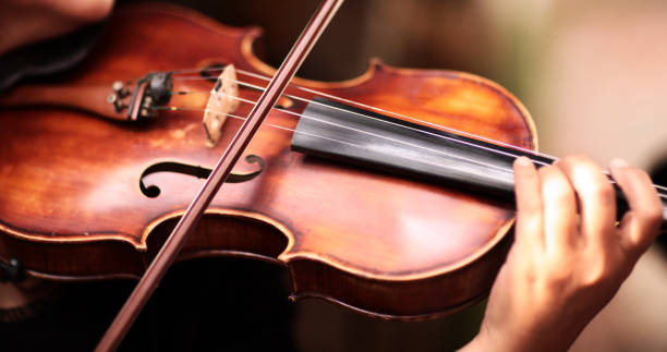 a person playing the violin showing hands holding the bow - violinista imagens e fotografias de stock