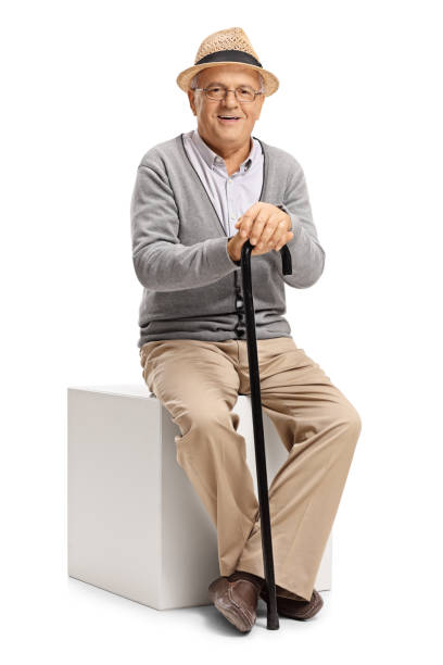 istock Mature man with a cane sitting on a cube 849250684