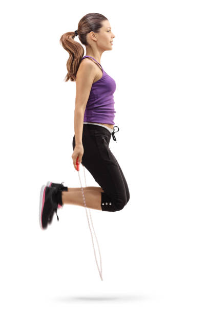 Profile shot of a young woman exercising with a jump rope isolated on white background