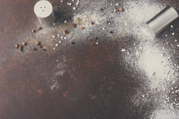 istock Scattered salt and pepper on dark background 849254036