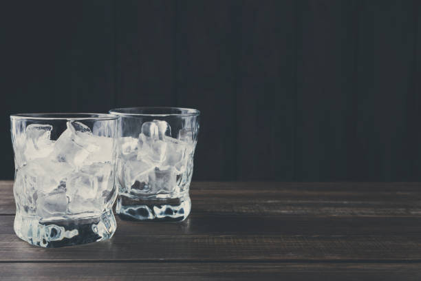 Glasses with ice cubes on dark background