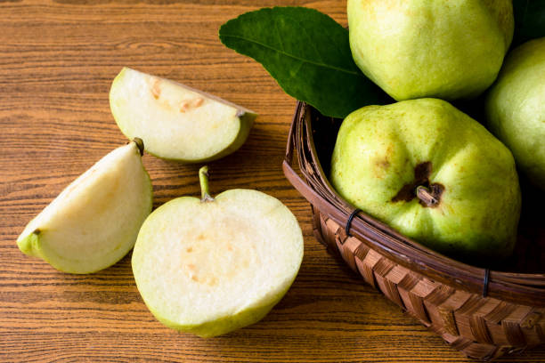 istock Fresh guava fruit in basket on wooden table background. 849254768