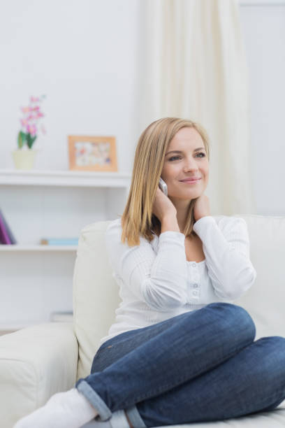istock Casual young woman using mobile phone at home 849257288