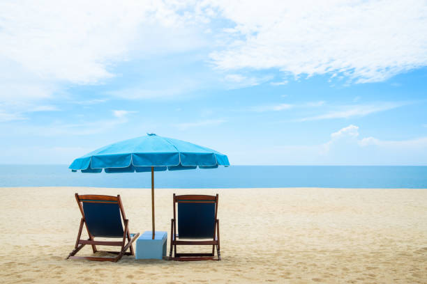 istock Beach chairs and blue umbrella on beautiful sand beach with cloudy and blue sky 849265946