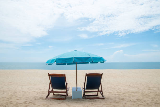 istock Beach chairs and blue umbrella on beautiful sand beach with cloudy and blue sky 849265986