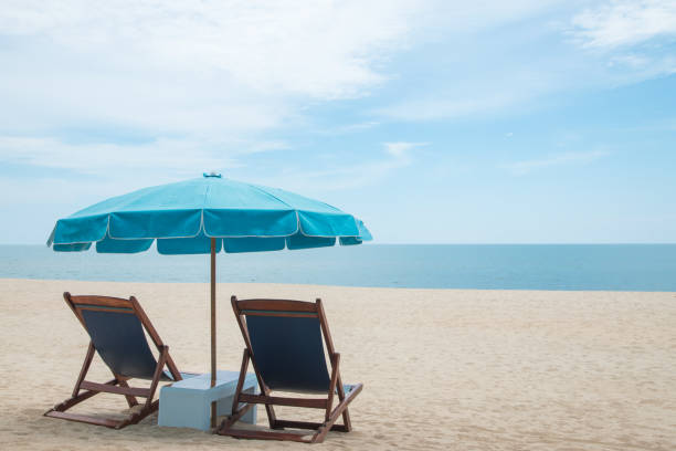 istock Beach chairs and blue umbrella on beautiful sand beach with cloudy and blue sky 849266020