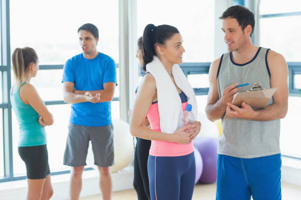 istock Fit couple with friends in background in exercise room 849273336