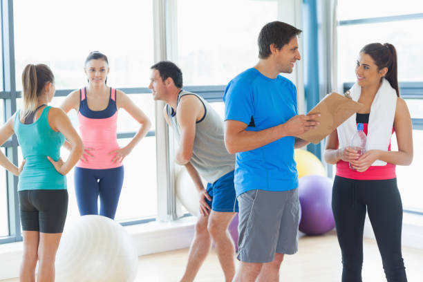 istock Fit couple with friends in background in exercise room 849273380