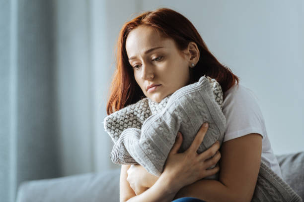 istock Sad depressed woman hugging a cushion 849273628