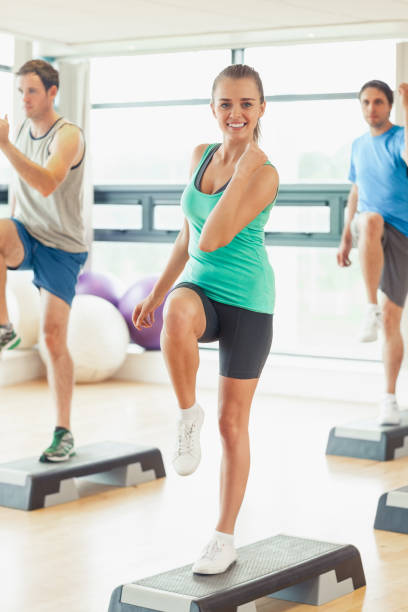 istock Instructor with fitness class performing step aerobics exercise 849273770