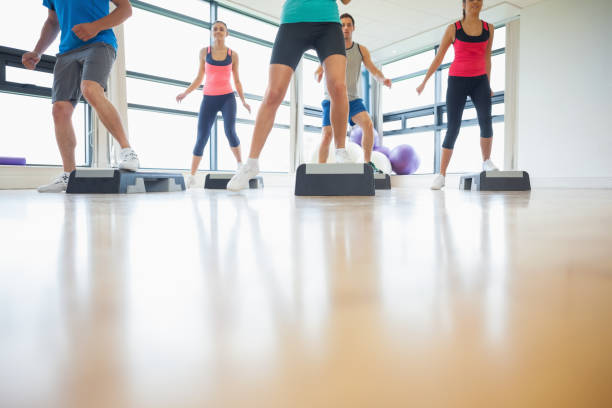 istock Instructor with fitness class performing step aerobics exercise 849273922