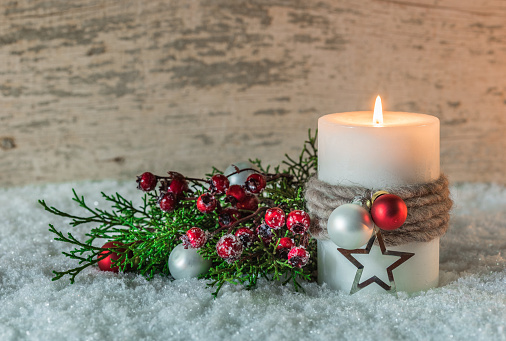 Decoration with burning candle and Christmas ornaments.