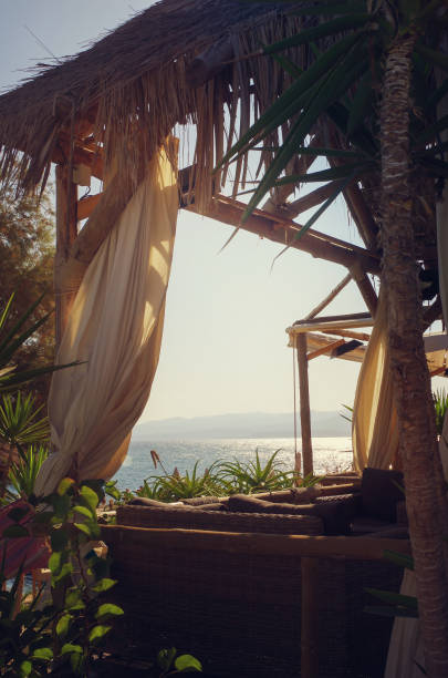istock Wooden canopy decorated with white curtains on the seashore 849274732