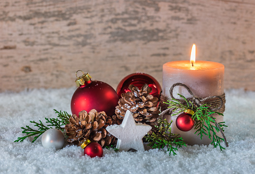 Christmas decoration with candle and fir branch on red background