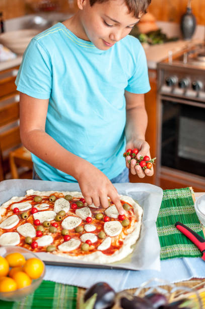 istock Boy Homemade Pizza Is Prepared For Baking 849287814