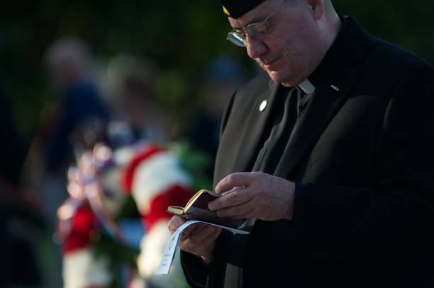 Philadelphia POW/MIA Memorial Ceremony Philadelphia, PA, USA - September 15, 2017: A chaplain reads from a book of prayer during  an observance of National POW/MIA Recognition Day in Philadelphia, Pennsylvania. religious occupation stock pictures, royalty-free photos & images
