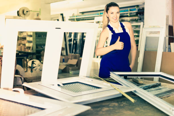 istock workwoman with plastic window frame in workshop giving thumbs up 849296486