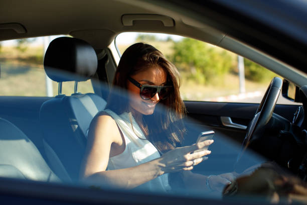 istock Attractive woman texting in a car on the road 849296512