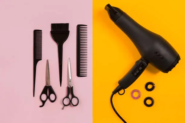 Photo of Combs and hairdresser tools on color background top view