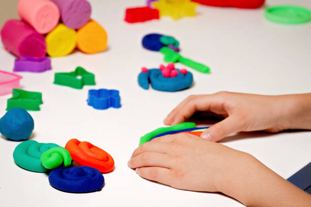 istock Child hands molding modeling clay or plasticine on white table 849306180