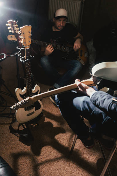 istock Guitarists rehearsing in dark music studio 849306966