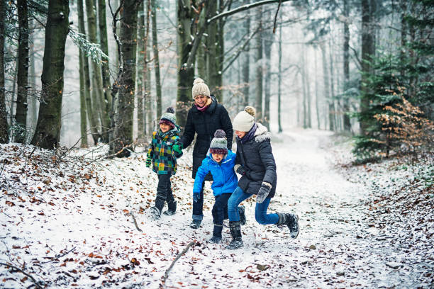 Mother with kids walking in beautiful winter forest
