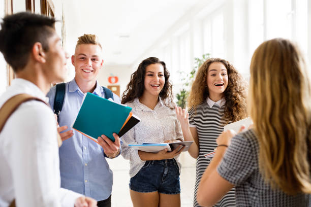istock Teenage students walking in high school hall, talking. 849317696
