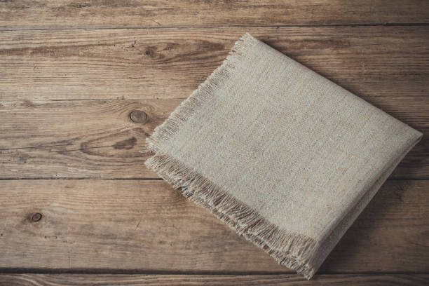 istock Folded linen napkin on old wooden kitchen table 849321904