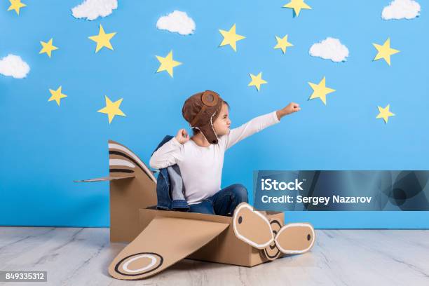 Little Child Girl In A Pilots Costume Is Playing And Dreaming Of Flying Over The Clouds Stock Photo - Download Image Now
