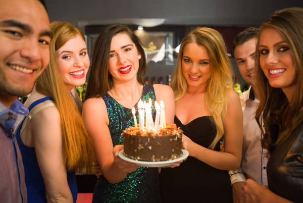 istock Happy friends celebrating brithday one holding birthday cake 849336836