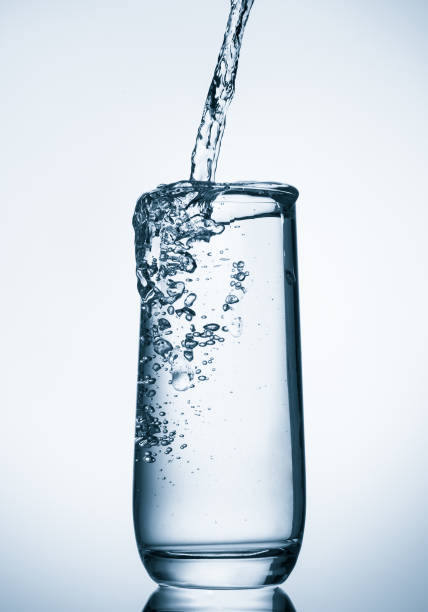 istock water pouring into glass on blue background 849342166