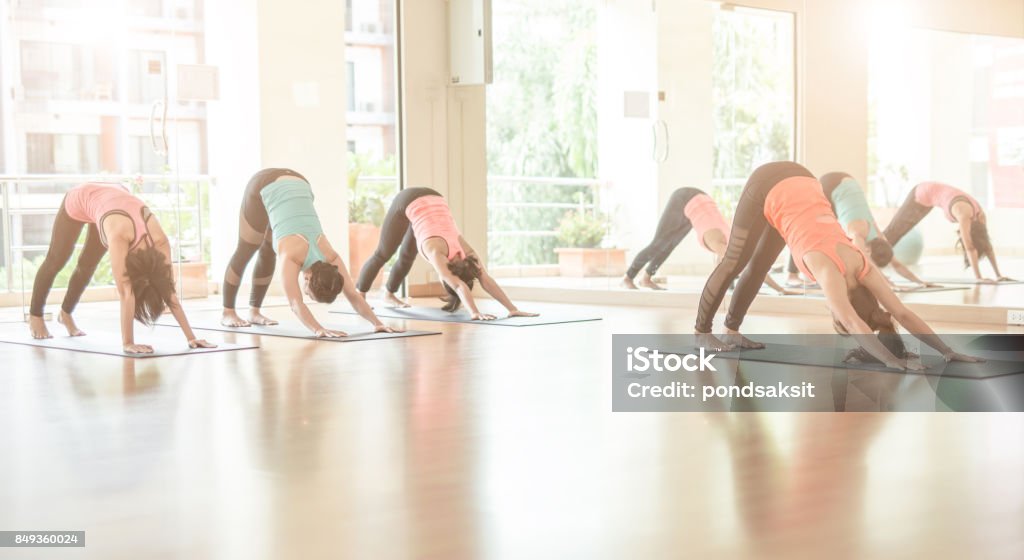 woman do exercise in gym.Doing Yoga fitness, sport, training, yoga and people concept - Asian woman do exercise in gym.Group Of female Doing Yoga Indoors Yoga Class Stock Photo