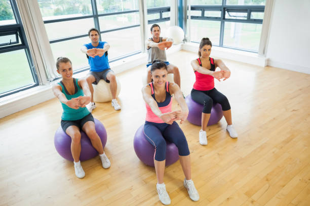 sportowcy wyciągają ręce na kulki do ćwiczeń na siłowni - joy the human body smiling women zdjęcia i obrazy z banku zdjęć