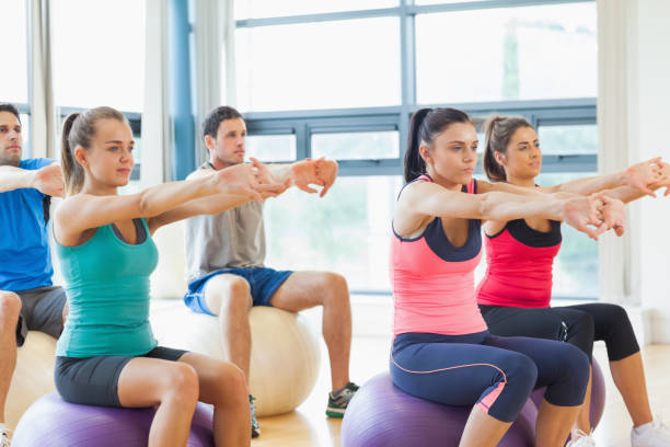 istock Sporty people stretching out hands on exercise balls at gym 849361268
