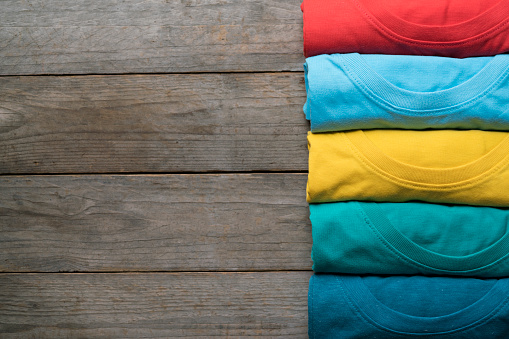 close up of rolled colorful clothes on wood table background