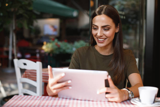 istock Young woman using a digital tablet in a cafe 849375924