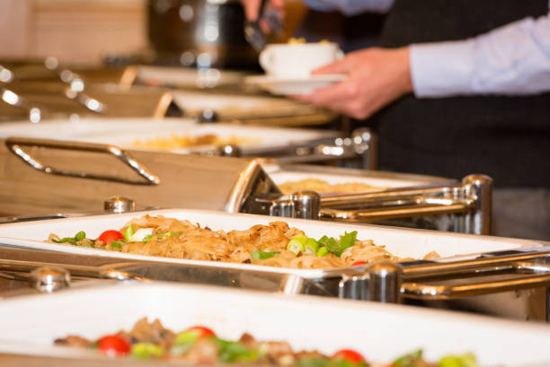 istock man picking food from chafing dish heaters 849378050