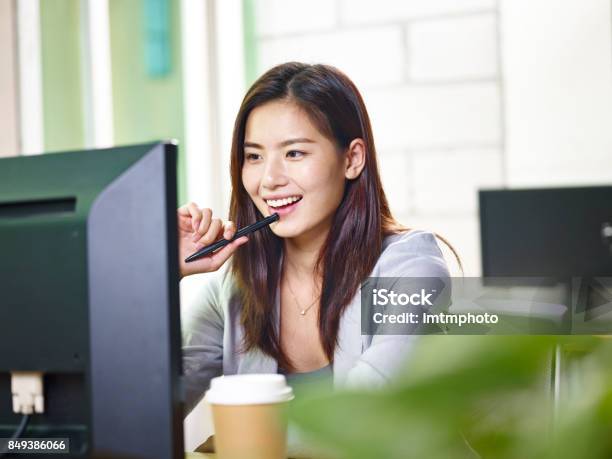 Young Asian Business Woman Working In Office Stock Photo - Download Image Now - Desktop PC, Smiling, Asian and Indian Ethnicities