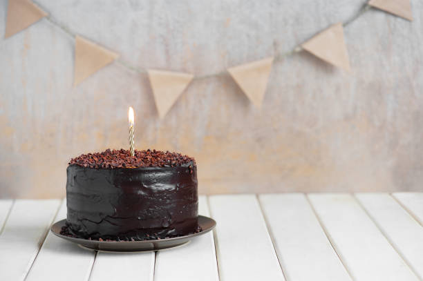 istock Chocolate birthday cake with burning candle 849392034