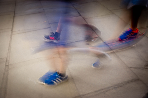 Motion blur on legs of three people all wearing Adidas trainers in Central London.