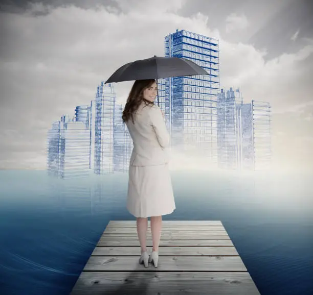 Photo of Rear view of businesswoman holding umbrella in front of holographic city