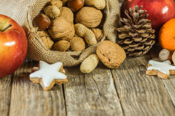 sfondo natalizio con biscotti, noci e frutta - peanut bag nut sack foto e immagini stock