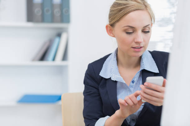 istock Young business woman text messaging at office desk 849403628