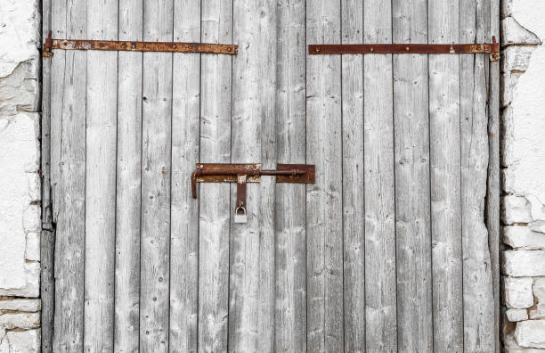 istock Old wooden gate warehouse. Closed on rusty metallic bolts 849409306