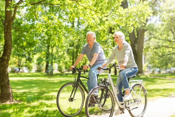 Photo of Senior Couple Riding Bikes In Park